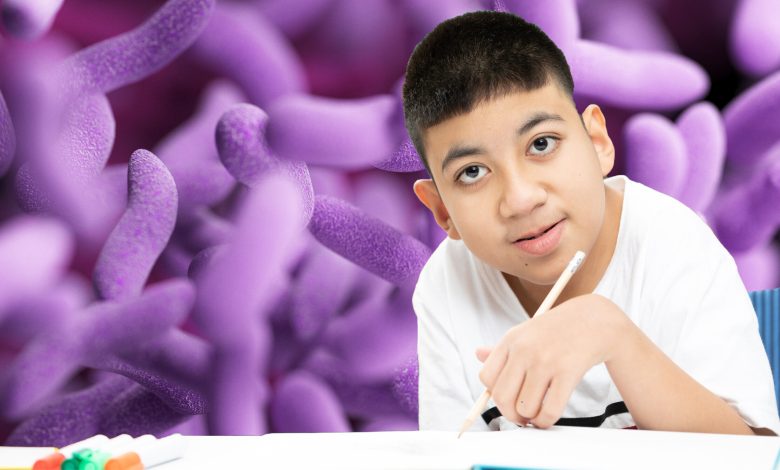 child with autism learning in the classroom. gut microbiome is the background of the image.